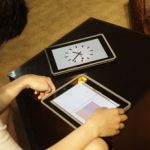 Student holding ipad with clock face on screen